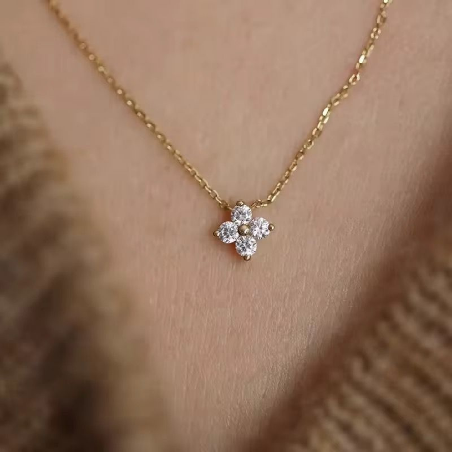 Four-Petal Crystal Flower Necklace by ZARIVA displayed on a jewellery bust, highlighting its floral crystal pendant and fine chain.
