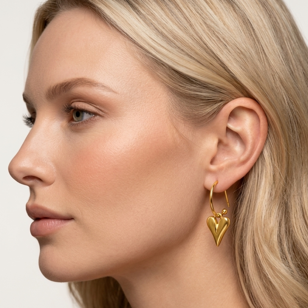 Gold heart earrings styled on a woman, showcasing the polished heart drop design and elegant everyday jewellery style by ZARIVA