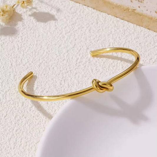 Knot cuff bracelet in polished gold featuring an intertwined knot detail, styled as an elegant statement bracelet by ZARIVA.