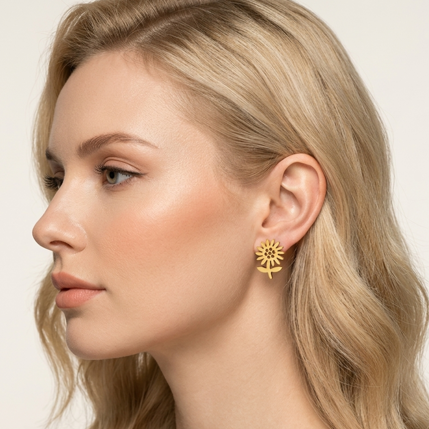 Model wearing ZARIVA Soleia Bloom Mini Floral Stud Earrings. Elegant minimalist flower earrings crafted from SS316L stainless steel with durable 18K PVD gold plating for everyday luxury.