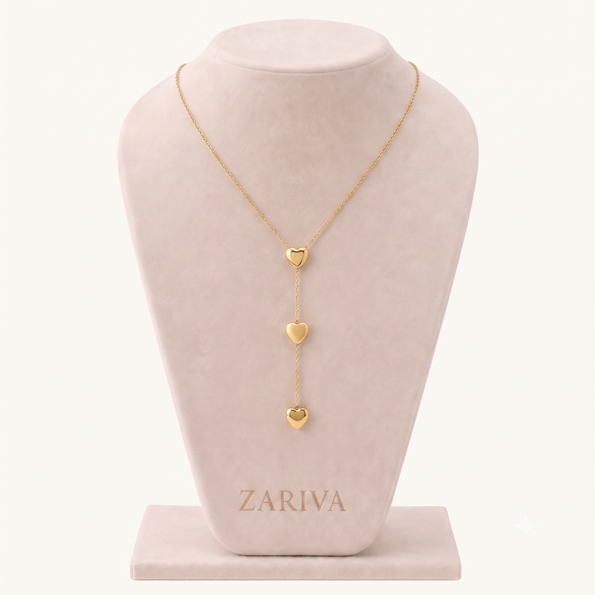 Amora Double Heart Lariat Necklace displayed on a jewellery bust, featuring three polished gold heart pendants on a fine chain.