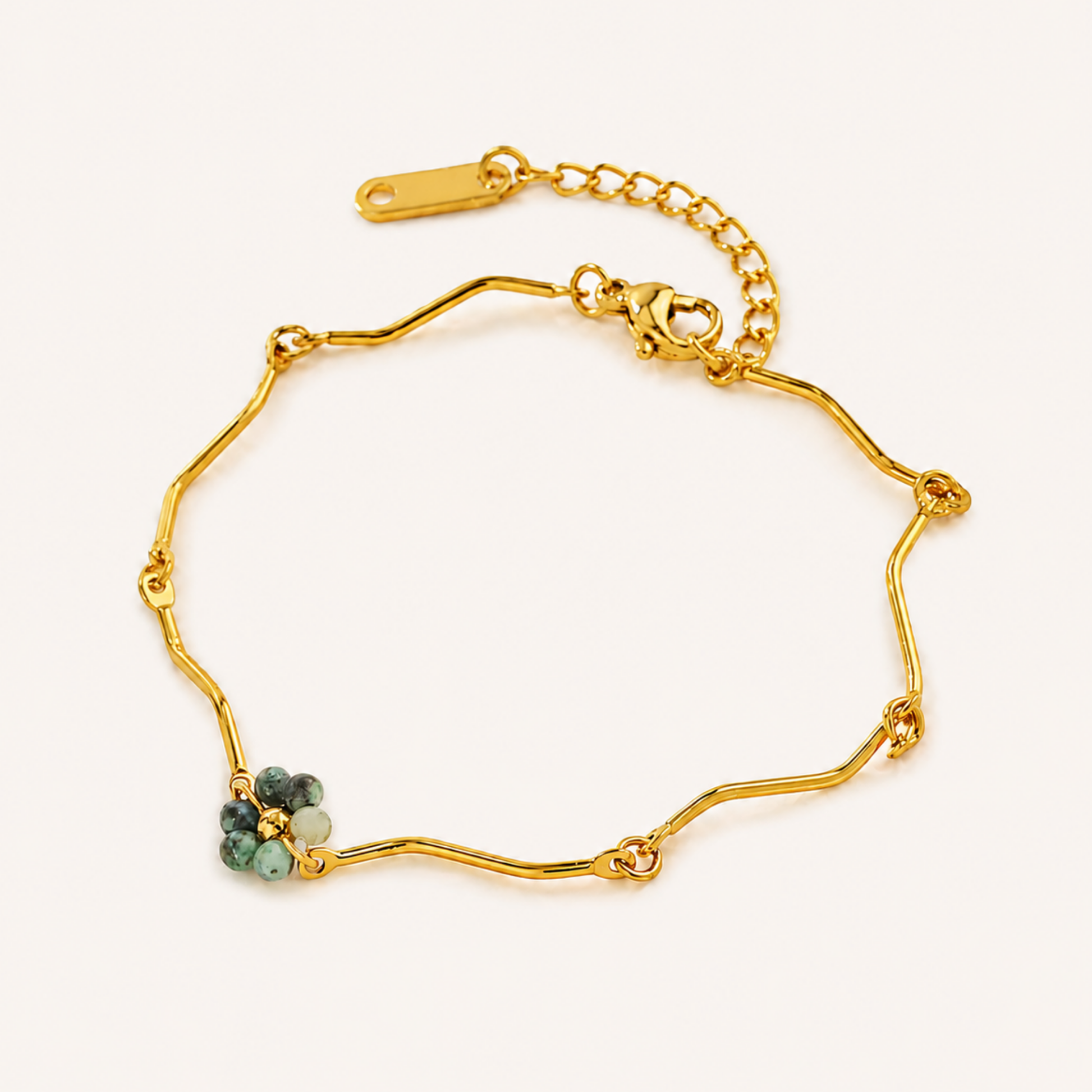 Beaded bracelet featuring a gold finish and green bead cluster, displayed on a clean background for detailed jewellery viewing.