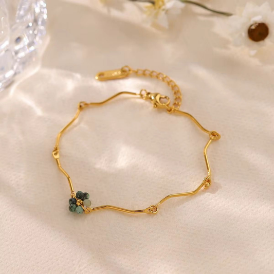 Beaded bracelet in gold with green beads styled on a woman's wrist for an elegant everyday jewellery look by ZARIVA.