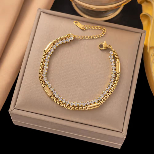 Double-row tennis bracelet in gold-tone finish displayed on a jewellery box, showcasing ZARIVA demi-fine jewellery.
