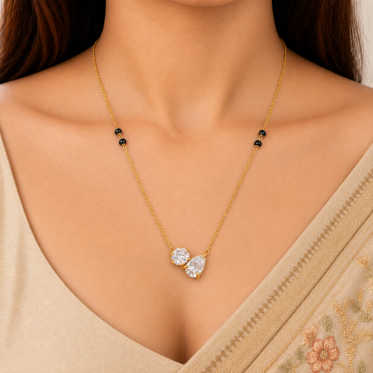 Duo crystal mangalsutra styled on a white outfit, showing its delicate gold-tone chain, black beads and sparkling dual-stone pendant.