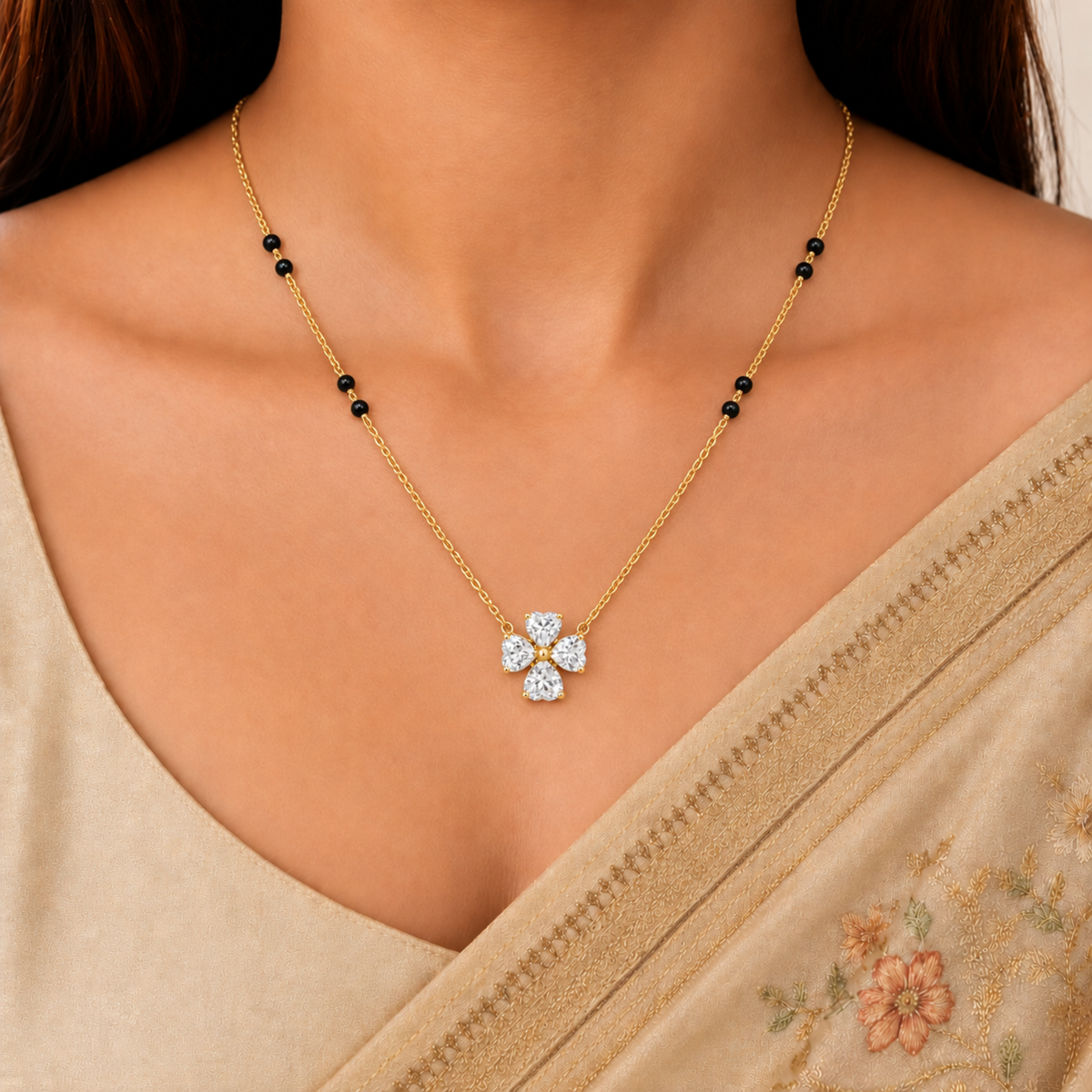 Four-stone zircon gold mangalsutra with black beads, styled on a model wearing a beige embroidered saree by ZARIVA.