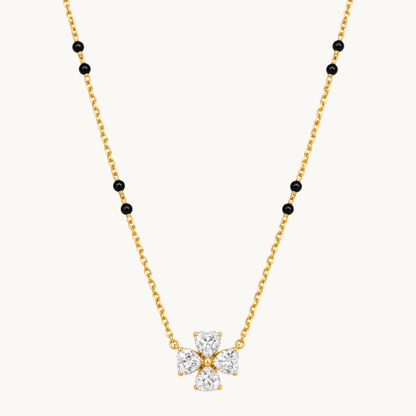 Gold mangalsutra necklace with black beads and a four-stone clear zircon flower pendant on a clean white background by ZARIVA.