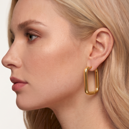 Gold rectangle hoop earrings worn on the ear, highlighting their elongated rounded shape and polished contemporary design by ZARIVA.