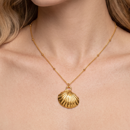 Gold seashell necklace for women shown worn at the neckline, highlighting its delicate chain and sculpted shell pendant