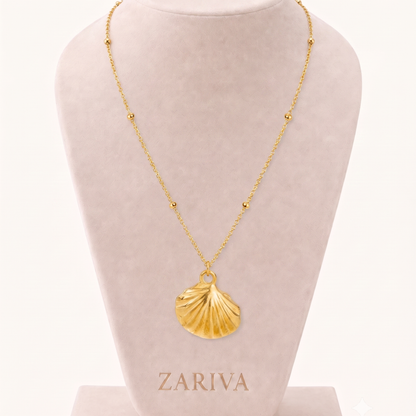 Gold seashell pendant necklace featuring a sculpted shell charm and delicate beaded chain, styled on a ZARIVA jewellery display