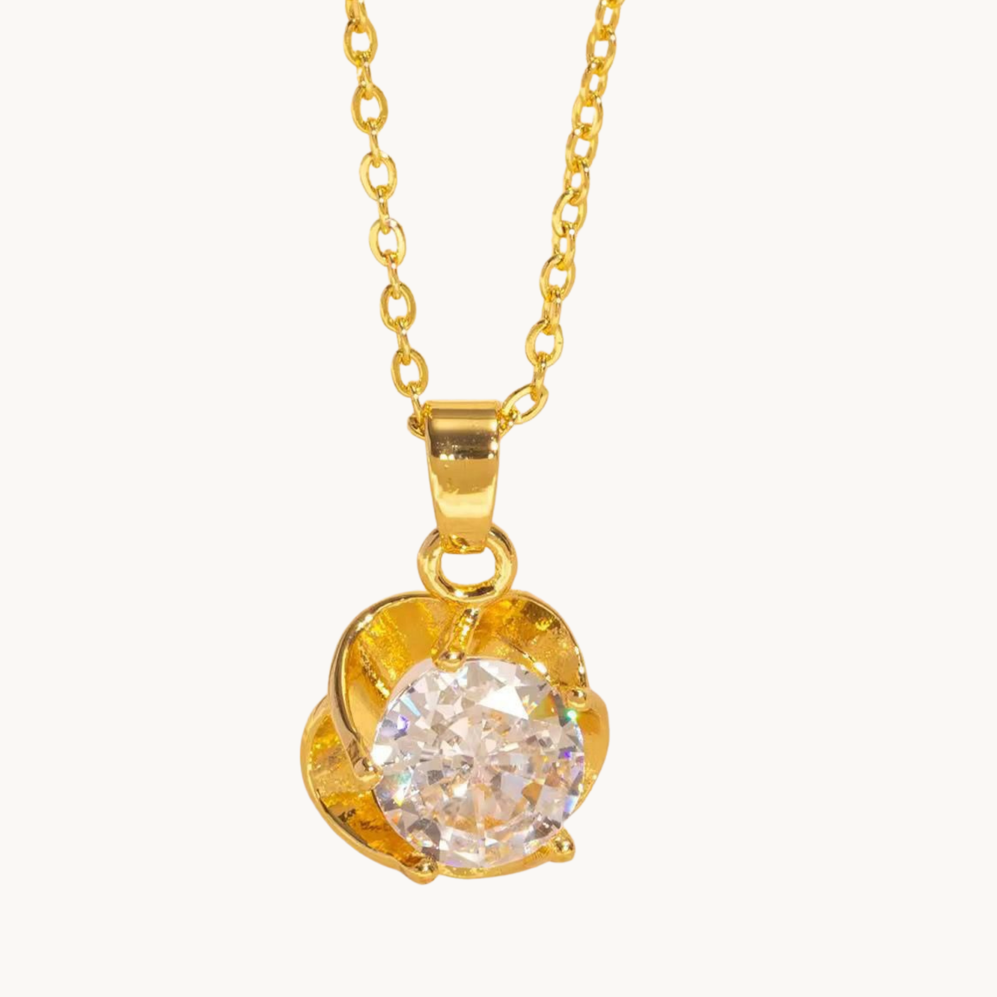 Gold solitaire necklace featuring a round clear center stone framed by a delicate floral-inspired pendant from ZARIVA.