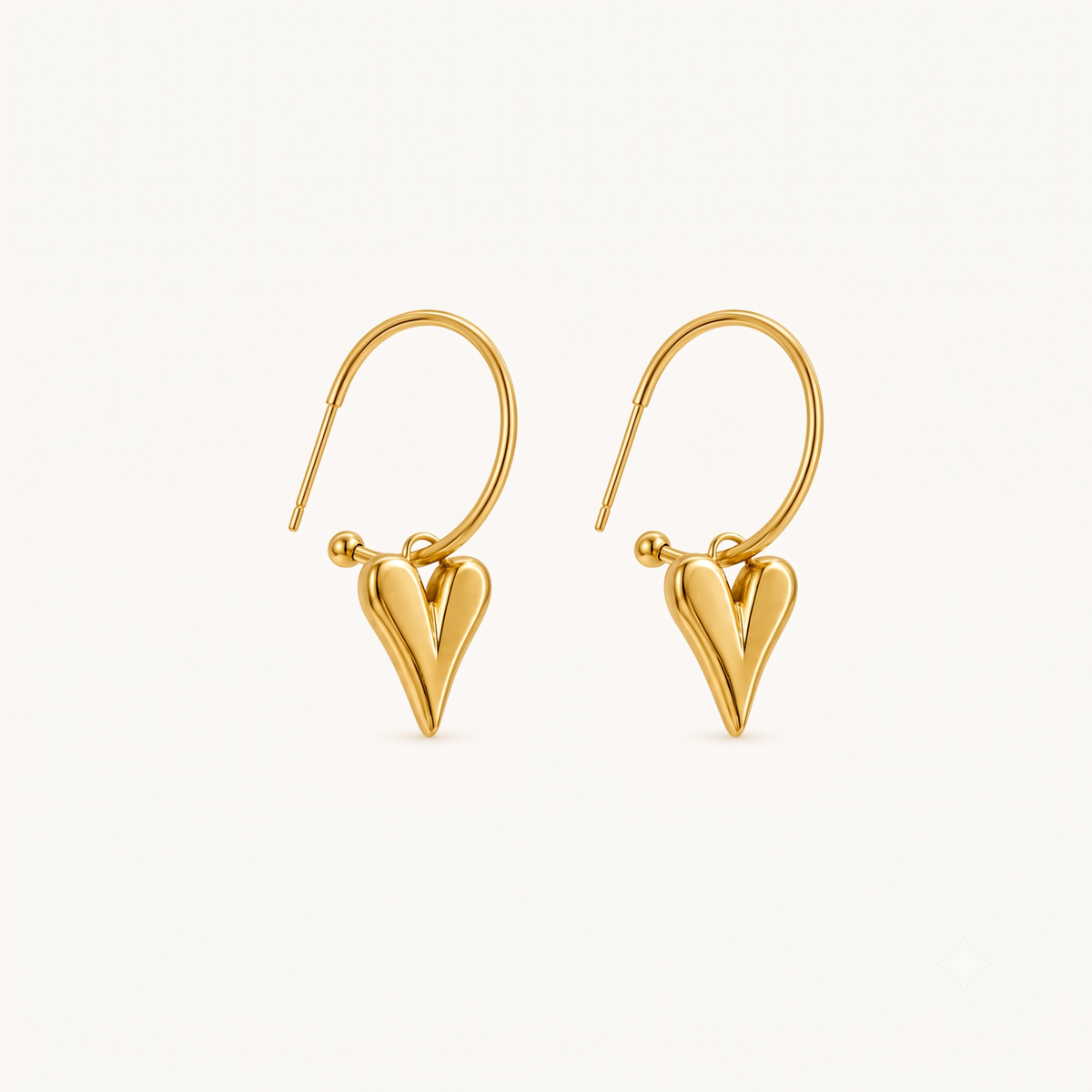 Gold heart earrings featuring sleek open hoops and polished sculptural heart drops, presented as elegant drop earrings by ZARIVA.