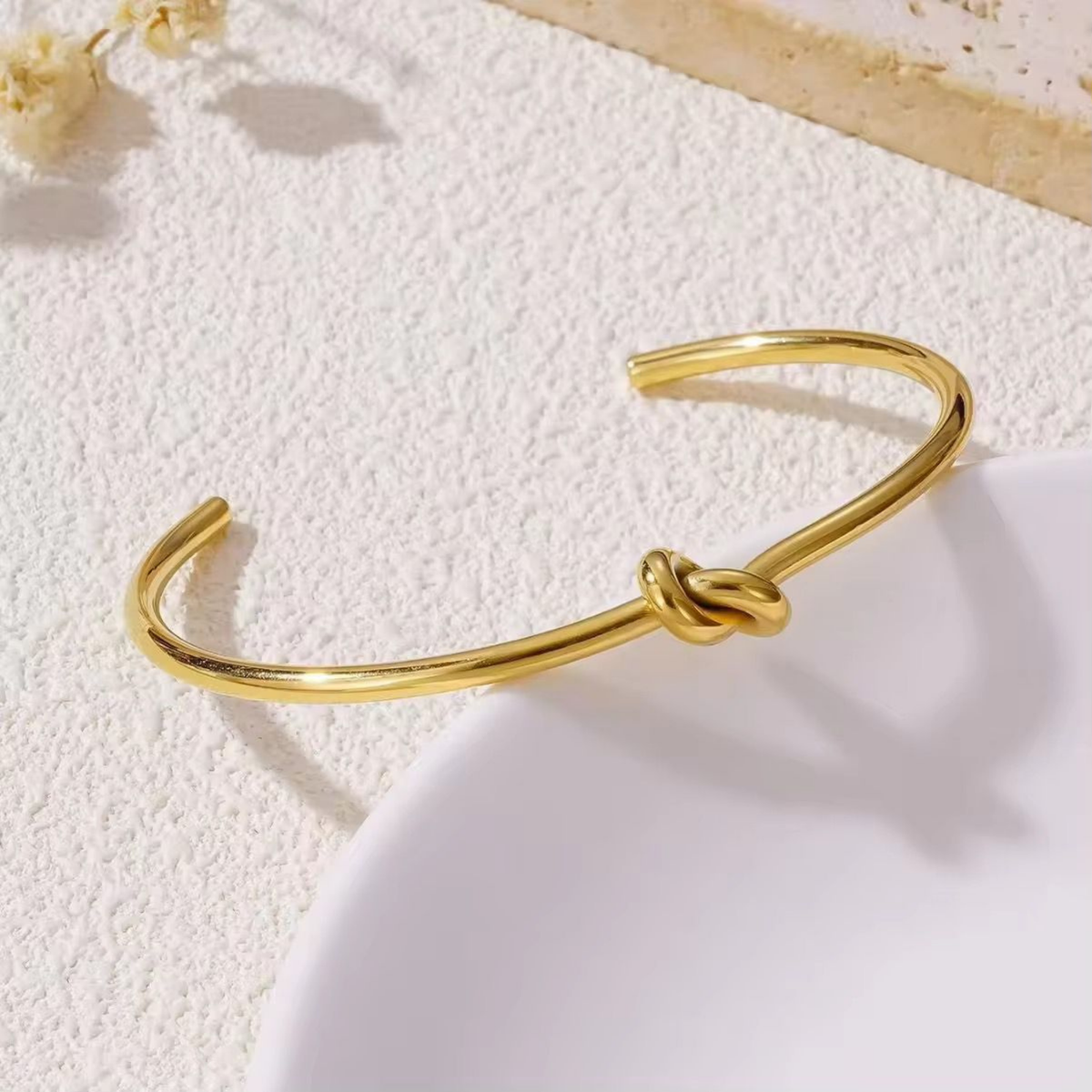 Knot cuff bracelet in polished gold featuring an intertwined knot detail, styled as an elegant statement bracelet by ZARIVA.