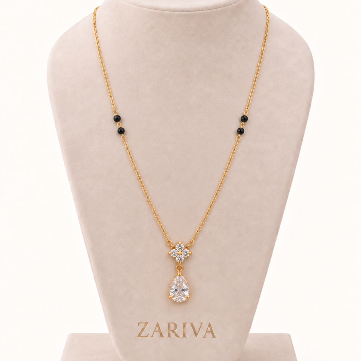 ZARIVA mangalsutra displayed on a jewellery bust with black beads, floral crystal pendant and gold-tone chain.