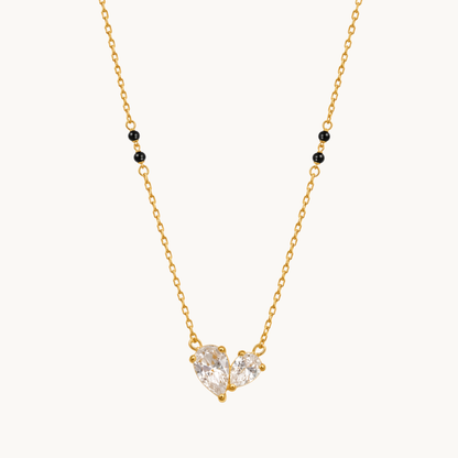 ZARIVA mangalsutra featuring a sparkling open heart pendant with faceted cubic zirconia stones and black beads.