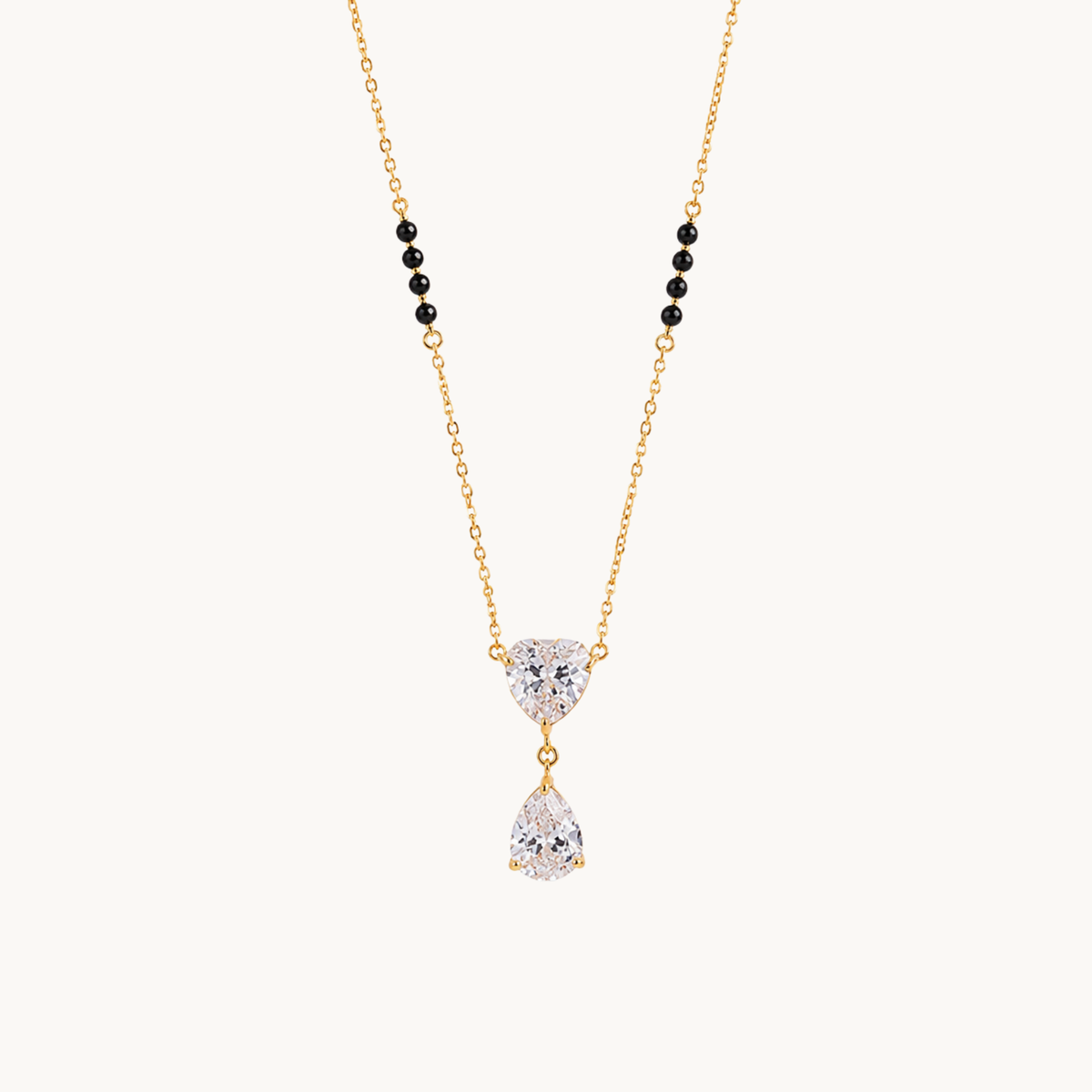ZARIVA heart pendant mangalsutra with black beads, a gold-tone chain and sparkling teardrop stone on a clean background.