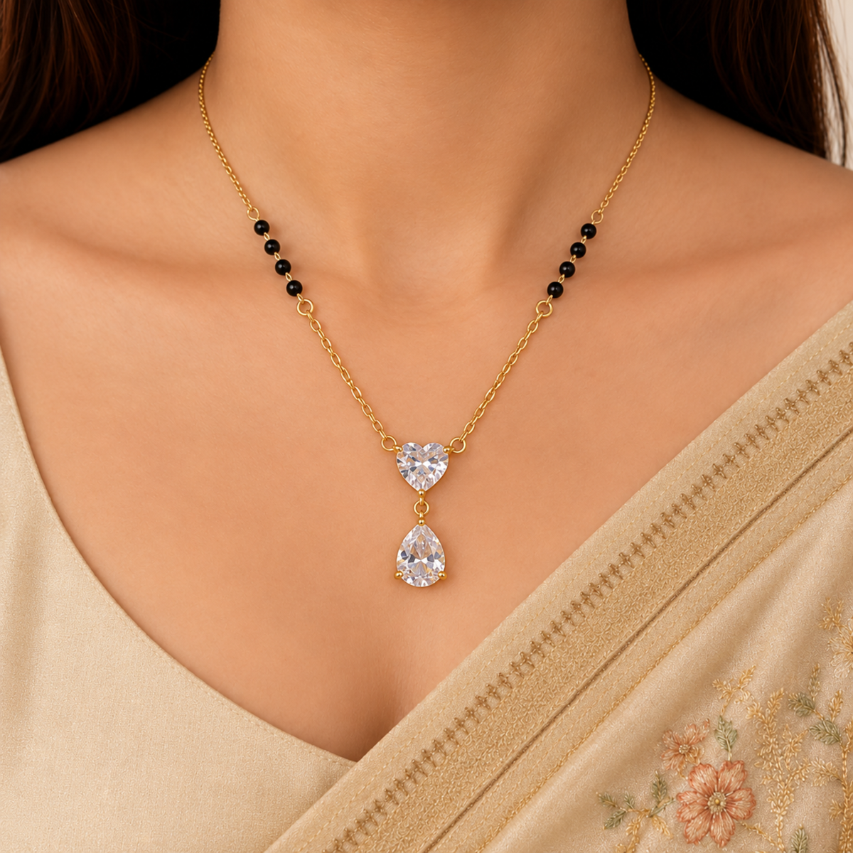 ZARIVA mangalsutra with a heart-shaped crystal pendant and teardrop drop, styled with an elegant Indian saree.