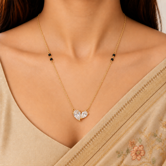 ZARIVA mangalsutra with an open heart-shaped crystal pendant styled with an elegant Indian saree.