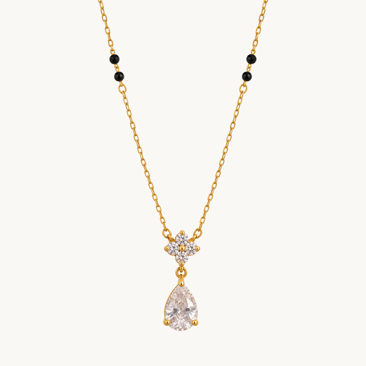 ZARIVA mangalsutra with black beads, a floral crystal cluster and sparkling teardrop pendant on a gold-tone chain.