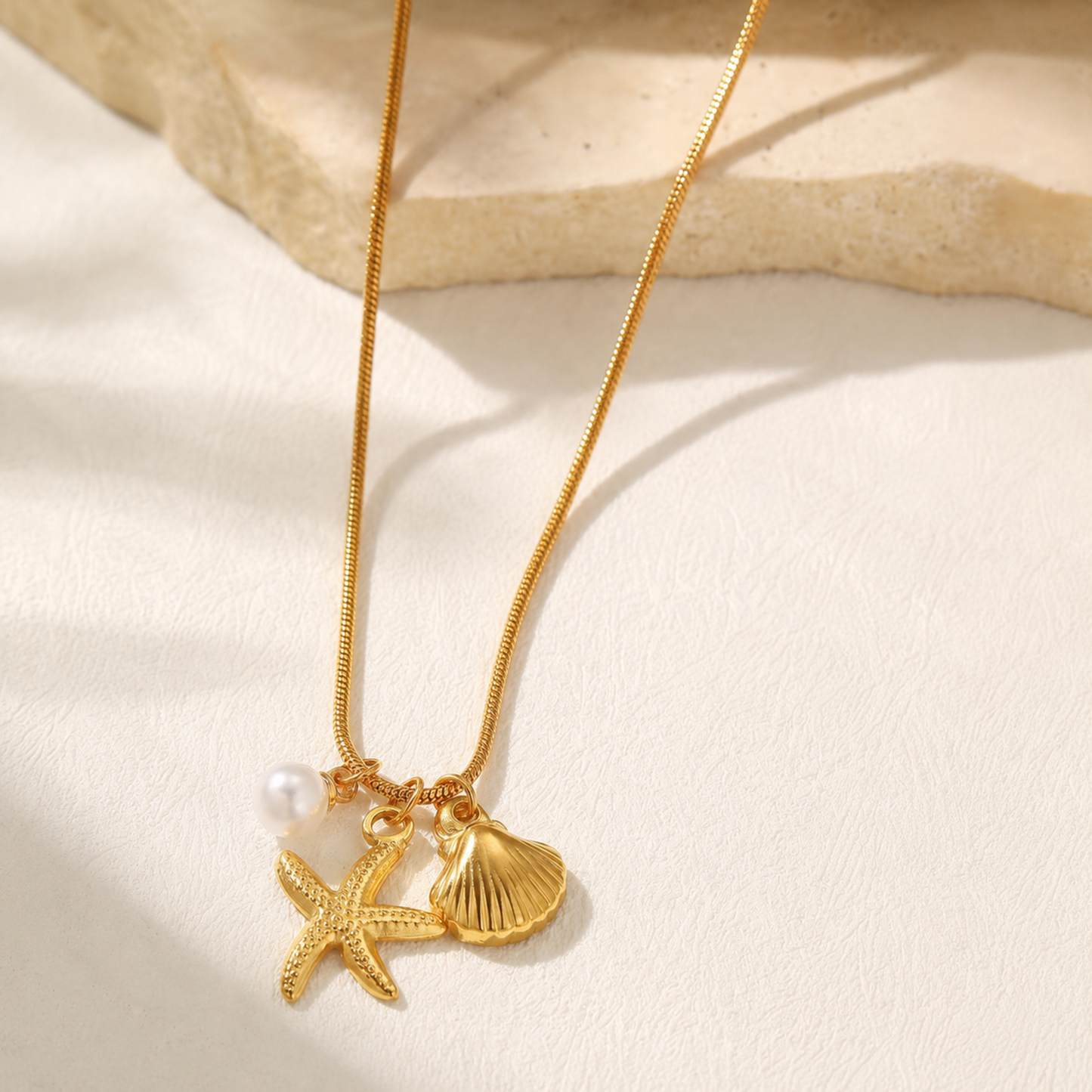Marina Pearl Starfish Charm Necklace by Zariva, 18K gold PVD anti-tarnish necklace with ocean inspired shell and pearl charms for women