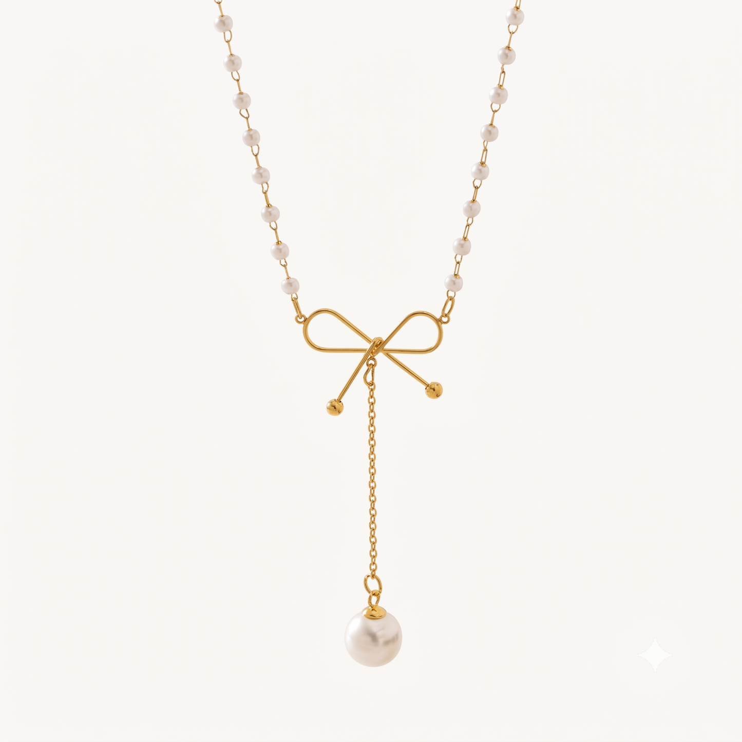 Pearl Bow Necklace featuring a delicate gold bow, pearl-beaded chain and a long dangling white pearl charm by ZARIVA