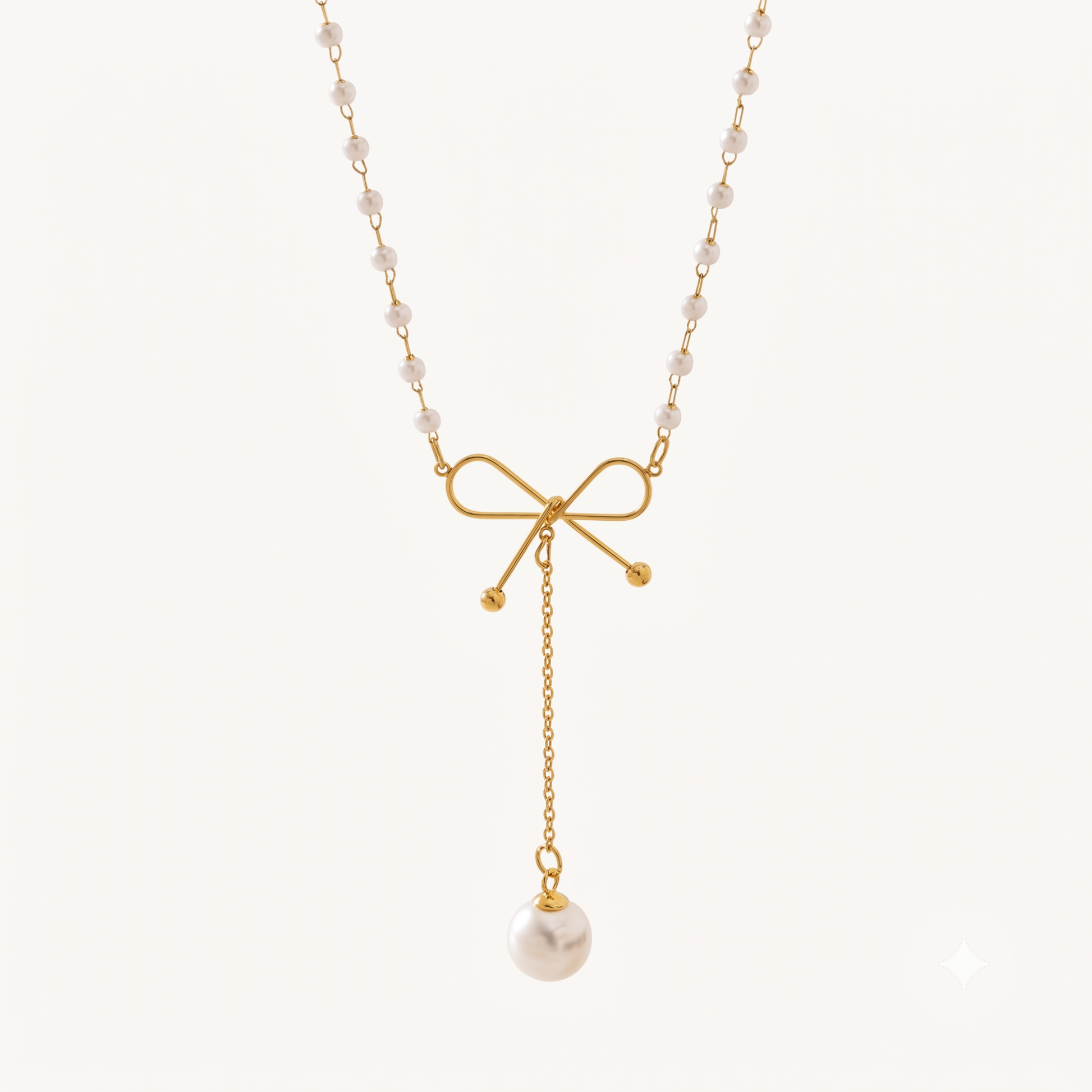 Pearl Bow Necklace featuring a delicate gold bow, pearl-beaded chain and a long dangling white pearl charm by ZARIVA
