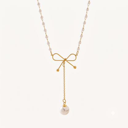 Pearl Bow Necklace featuring a delicate gold bow, pearl-beaded chain and a long dangling white pearl charm by ZARIVA