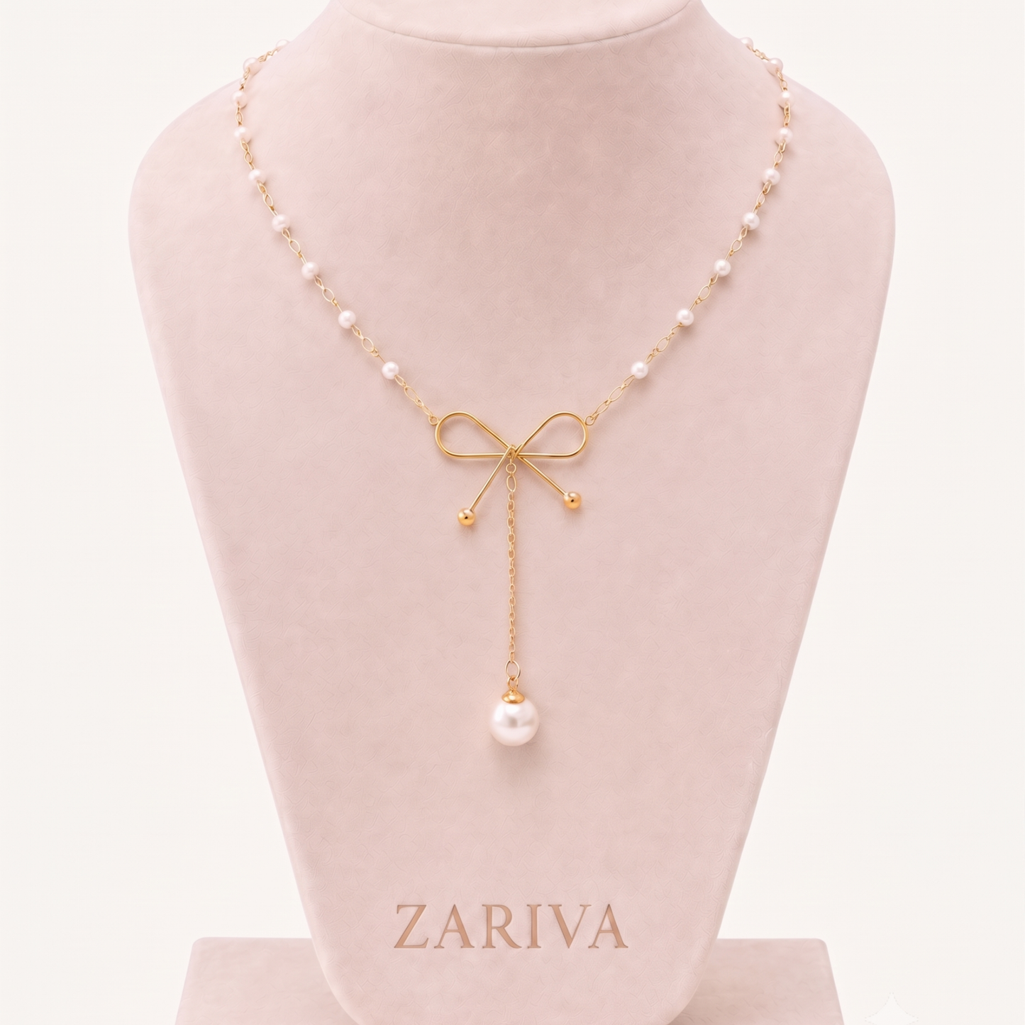 Pearl Bow Necklace displayed on a jewellery bust, highlighting its gold bow design, pearl chain and statement pearl pendant