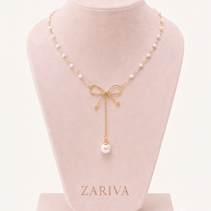 Pearl Bow Necklace displayed on a jewellery bust, highlighting its gold bow design, pearl chain and statement pearl pendant