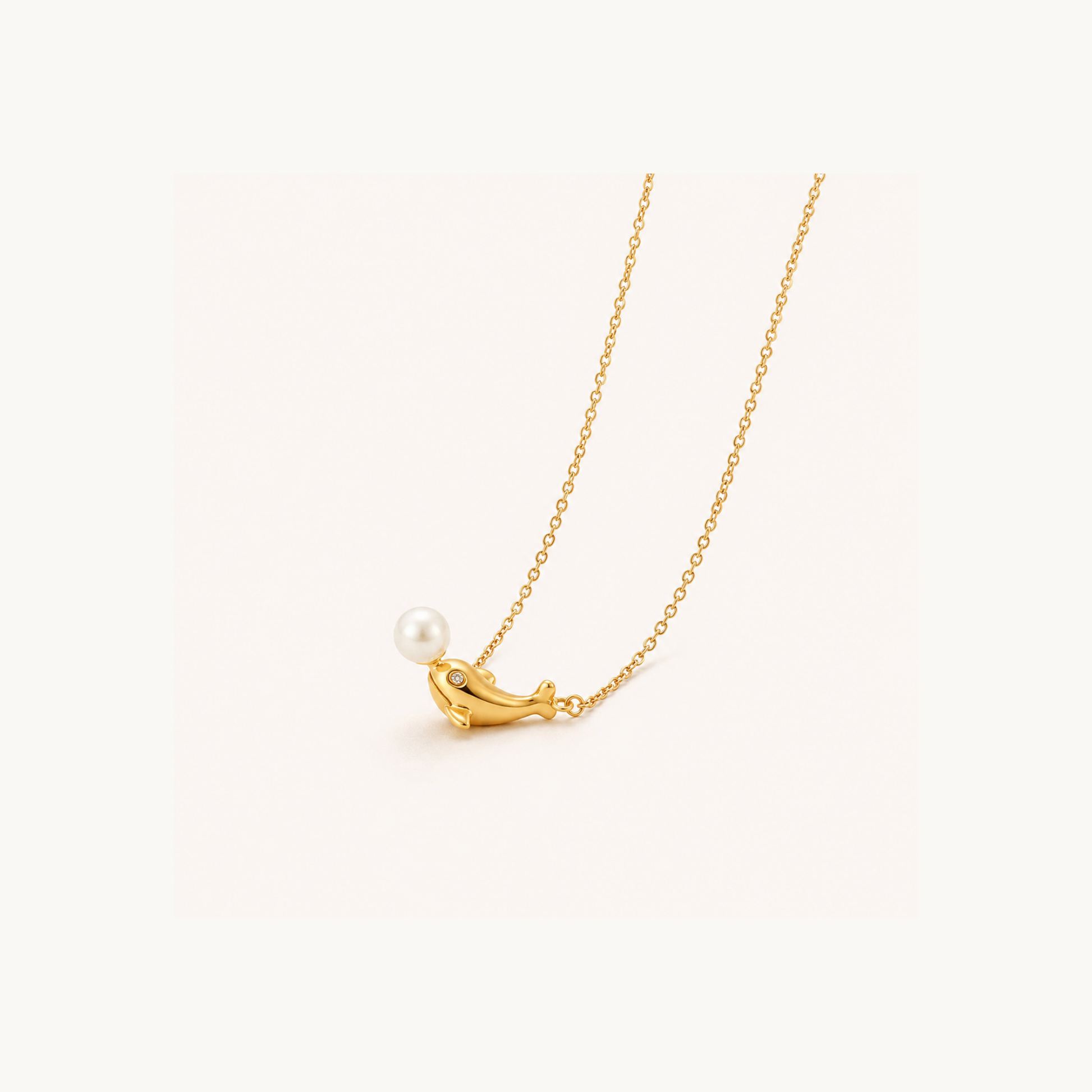 Pearl dolphin pendant necklace displayed on a soft neutral background, highlighting its gold finish, delicate chain and pearl detail.