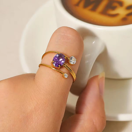 Purple gemstone ring with a double-band gold design and clear accent stones, styled as an elegant everyday jewellery piece.