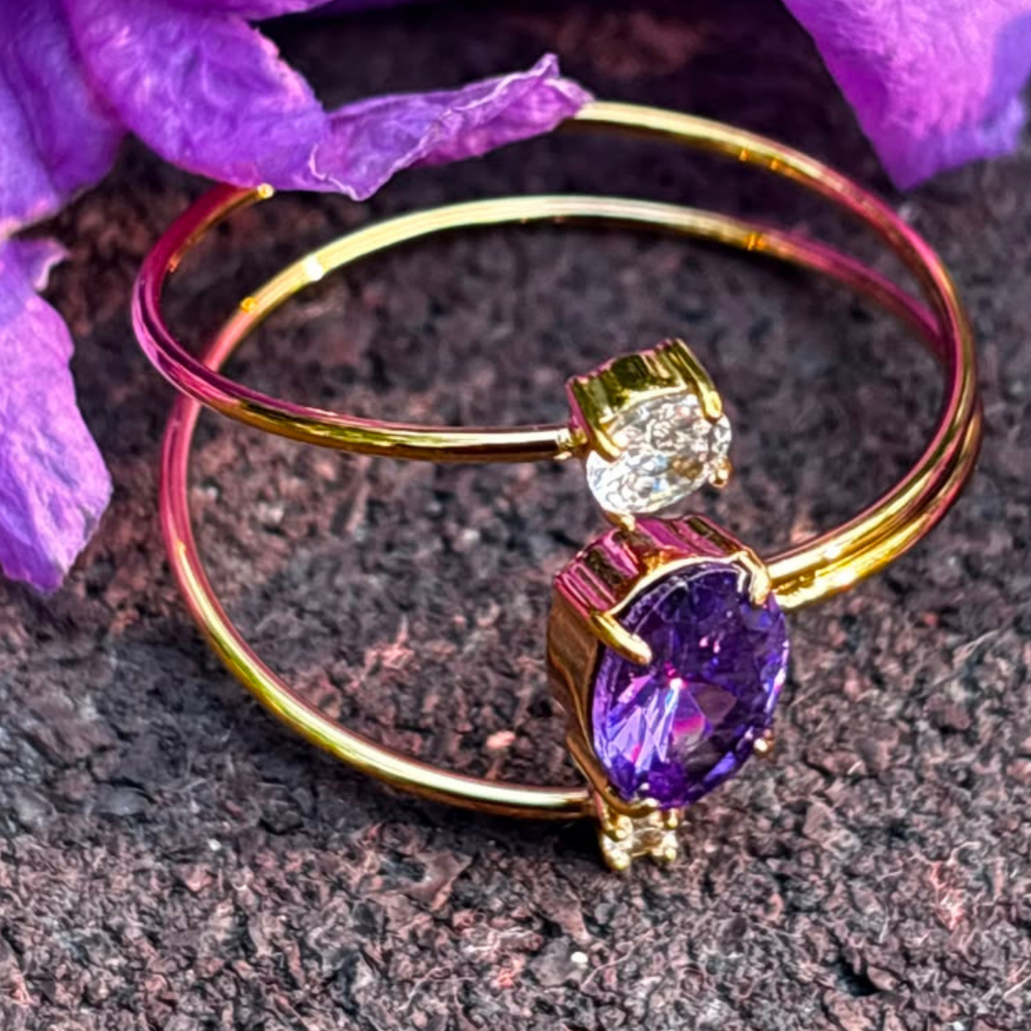 Purple gemstone ring with a double-band gold design and clear accent stones, styled as an elegant everyday jewellery piece.
