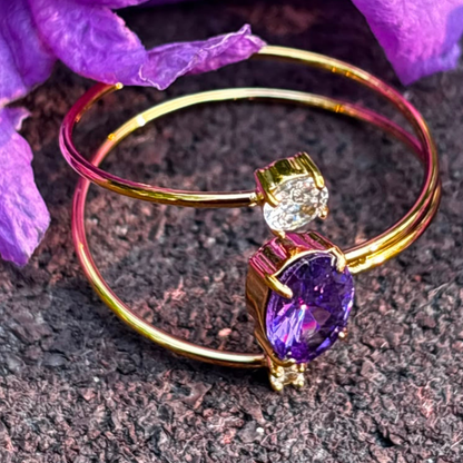 Purple gemstone ring with a double-band gold design and clear accent stones, styled as an elegant everyday jewellery piece.
