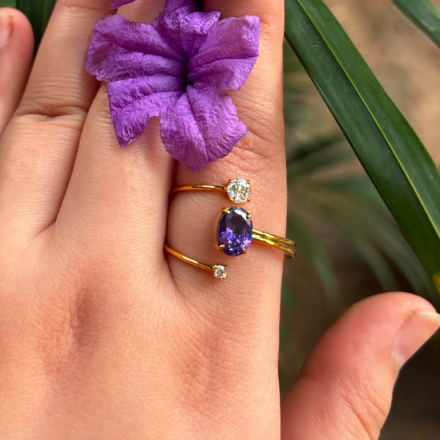 Purple gemstone ring with a double-band gold design and clear accent stones, styled as an elegant everyday jewellery piece.