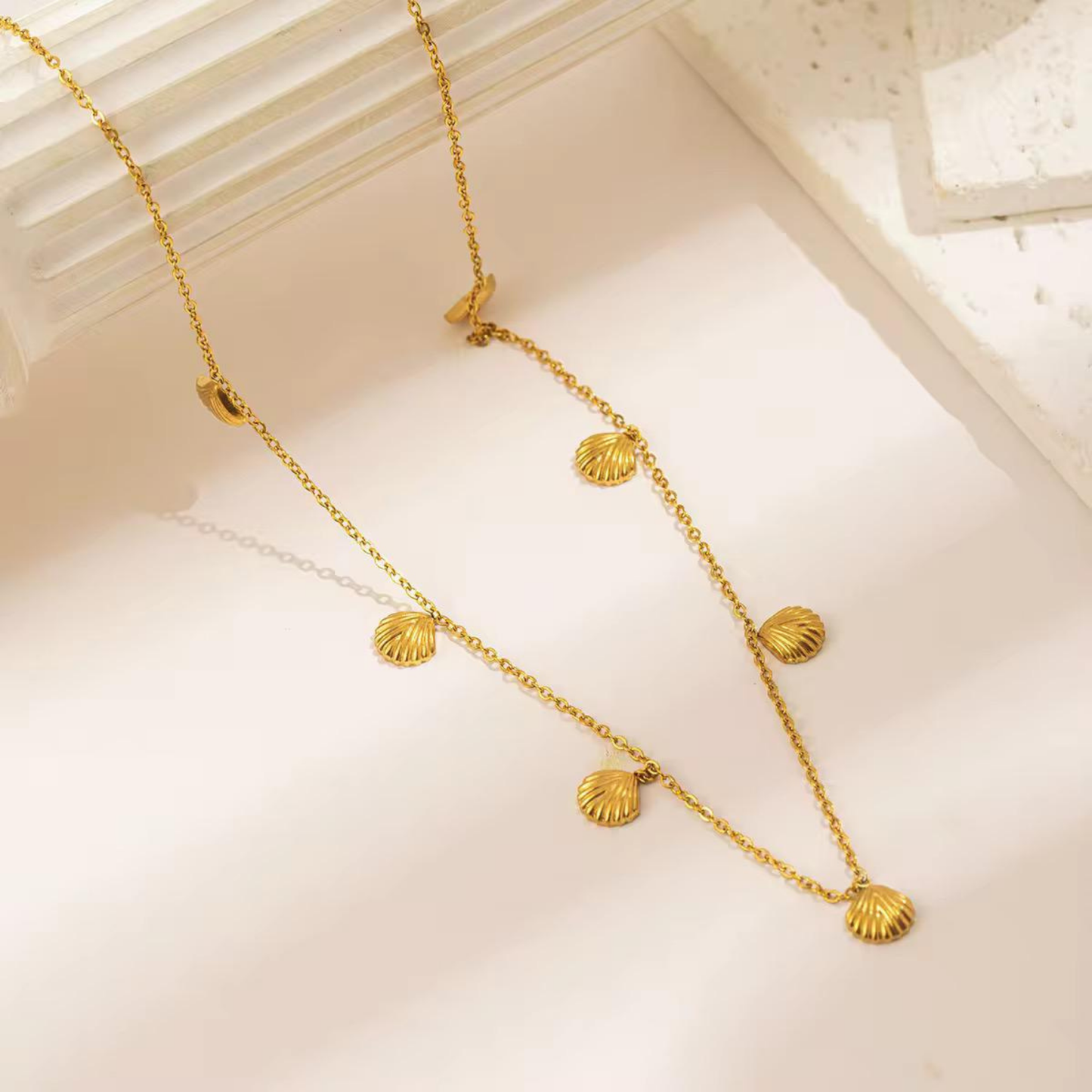 Seashell necklace styled flat with detailed gold shell charms, highlighting the delicate chain and coastal-inspired design by ZARIVA.
