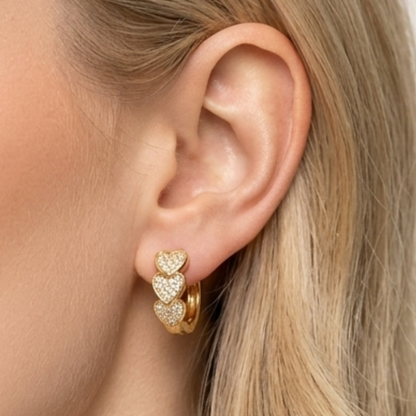 Valentina Heart Glow Huggie Earrings by Zariva featuring triple heart zircon design, 18K Gold PVD finish and anti-tarnish stainless steel jewellery for women