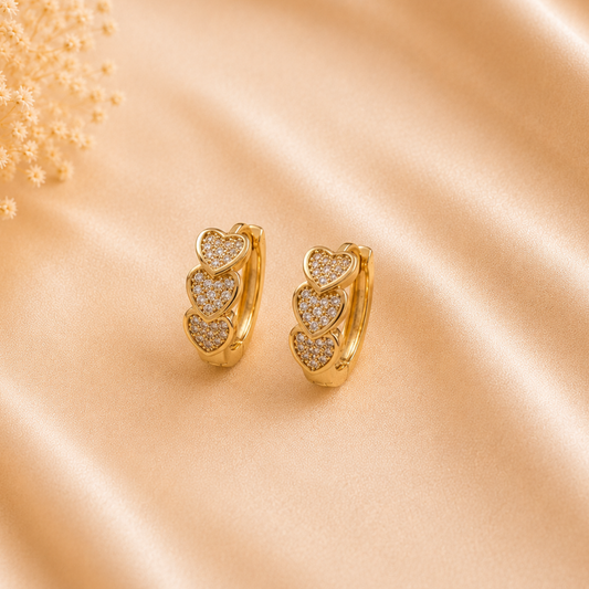 Valentina Heart Glow Huggie Earrings by Zariva featuring triple heart zircon design, 18K Gold PVD finish and anti-tarnish stainless steel jewellery for women