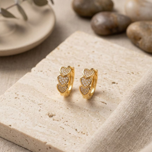 Valentina Heart Glow Huggie Earrings by Zariva featuring triple heart zircon design, 18K Gold PVD finish and anti-tarnish stainless steel jewellery for women