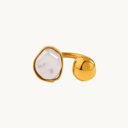White stone open ring with a gold finish worn on a woman's hand, showcasing its sculptural design and elegant everyday style.
