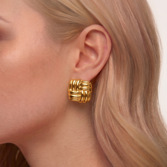 Woven knot earrings with polished gold-tone bands and a sculptural interwoven design, styled as elegant ZARIVA earrings.