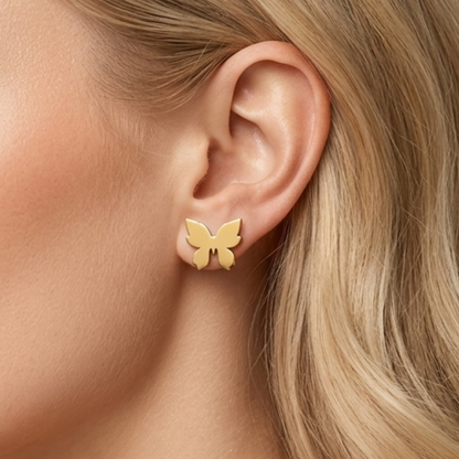 Close-up of ZARIVA Mariposa Mini Butterfly Stud Earrings worn on the ear. Small butterfly earrings under 1 cm made from SS316L stainless steel with 18K PVD gold plating for everyday luxury.